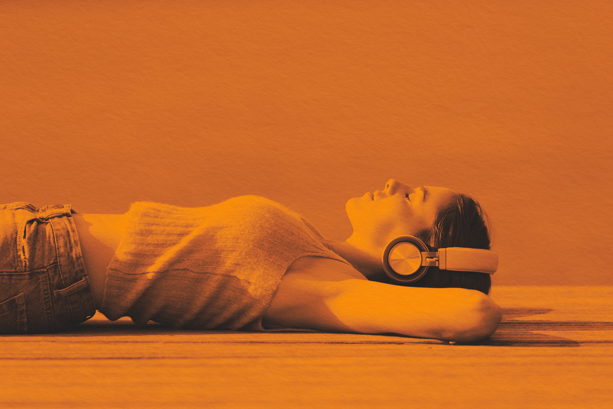 Woman relaxing listening to music on the ground