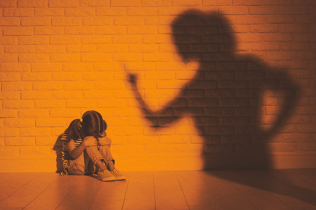 Angry mother scolds frightened daughter sitting on floor