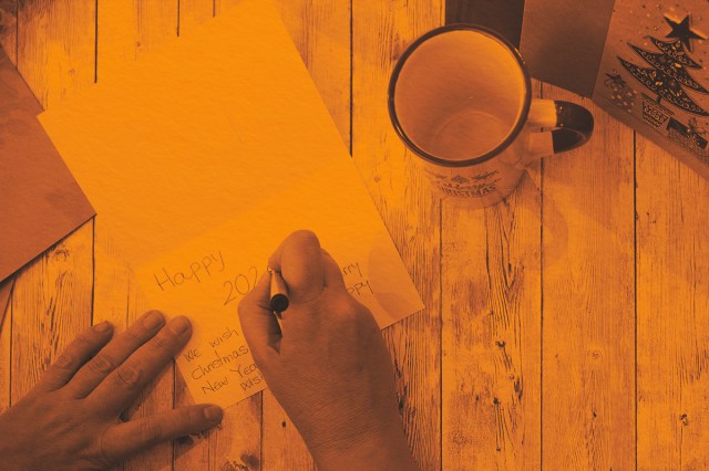 writing a Christmas card on a wooden table