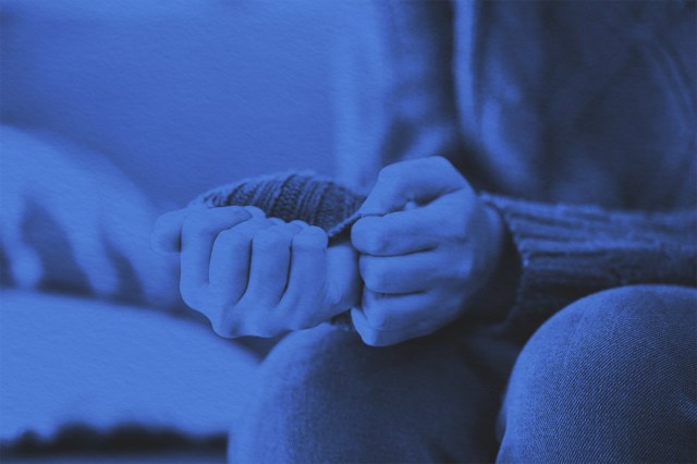 Close-up of nervous anxious hands pulling on sweater