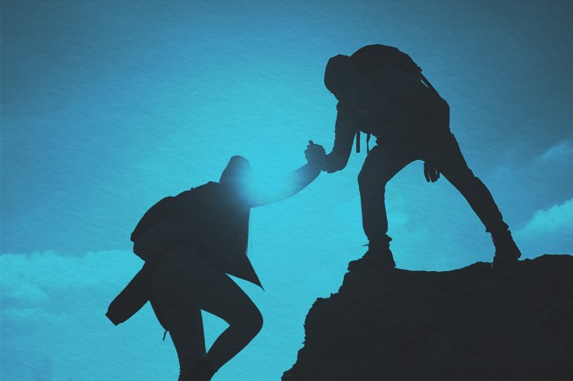 Tourist lends a helping hand while climbing a mountain cliff