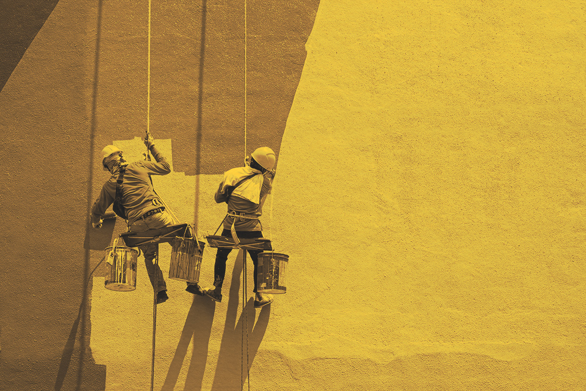 Two painters painting the exterior of a building