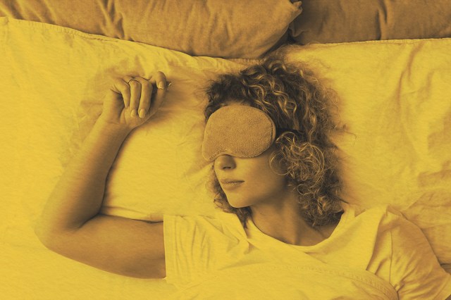 Woman sleeping in bed with a sleep mask on