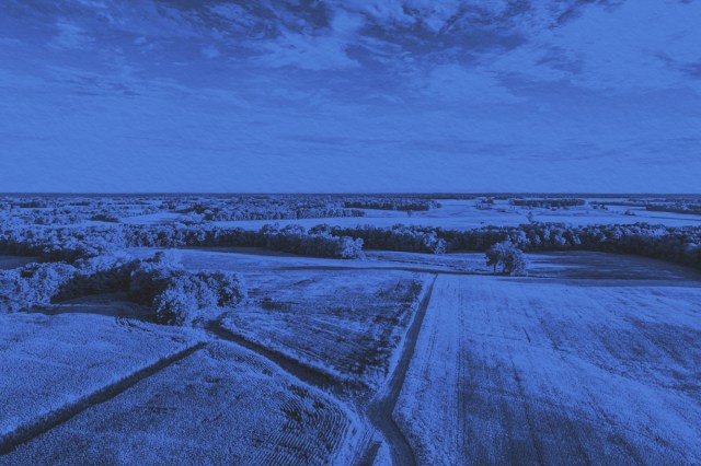 Aerial photo over a field and dirt road lanes