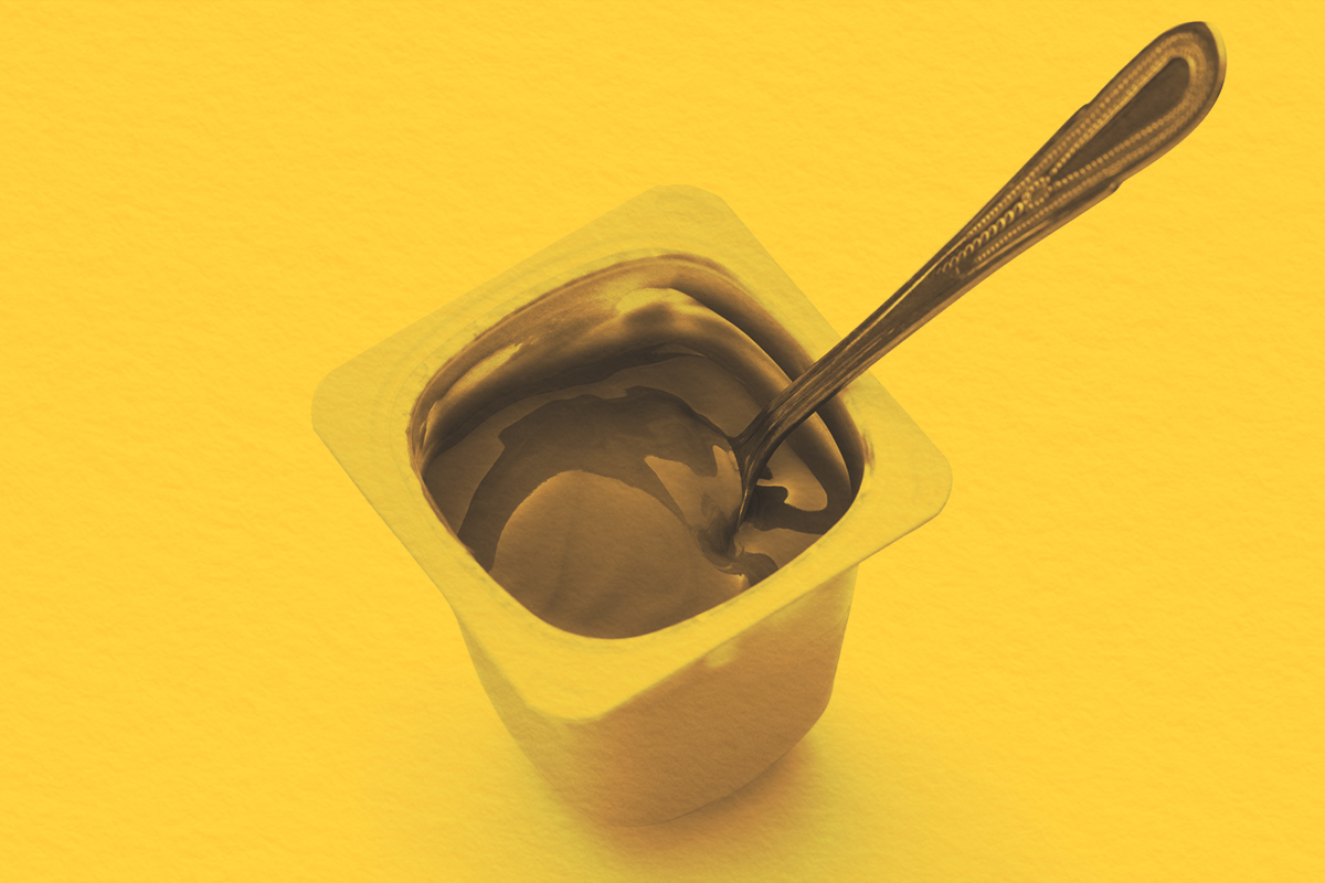 Open pudding cup with a metal spoon