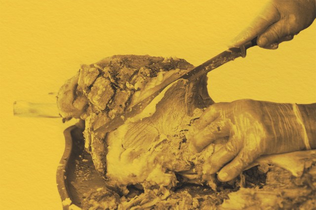 Man with knife cutting slices of the roasted pork