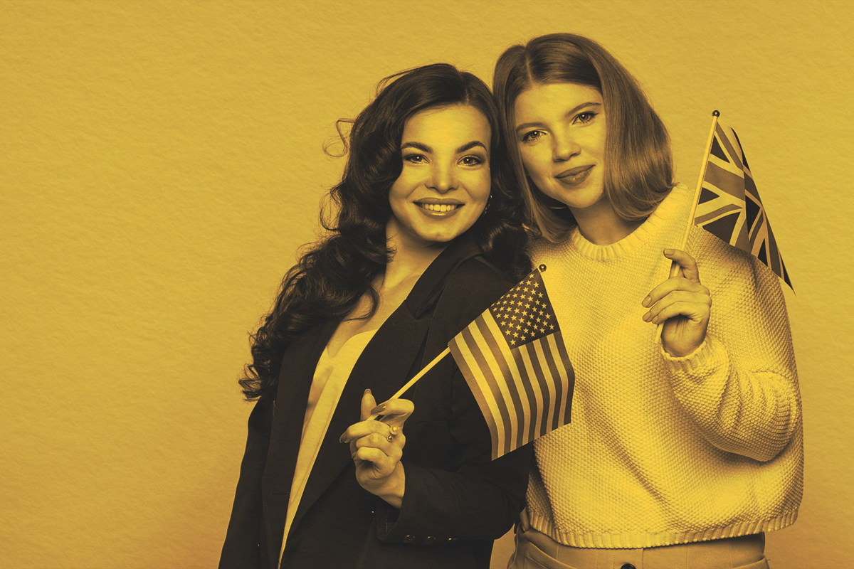 Two women holsing American and British flags