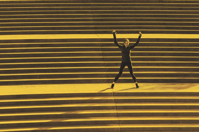 Woman doing jumping jacks on stairs