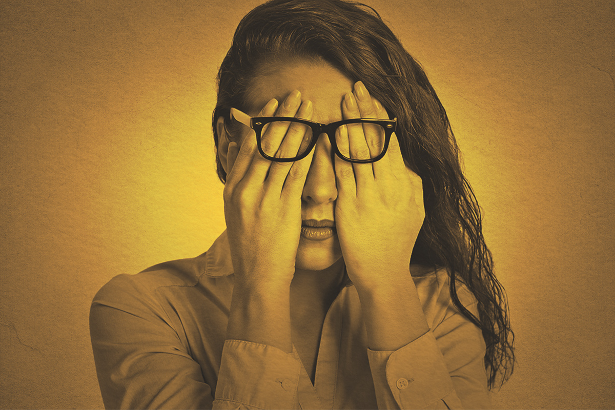 Woman in glasses covering face eyes using her both hands
