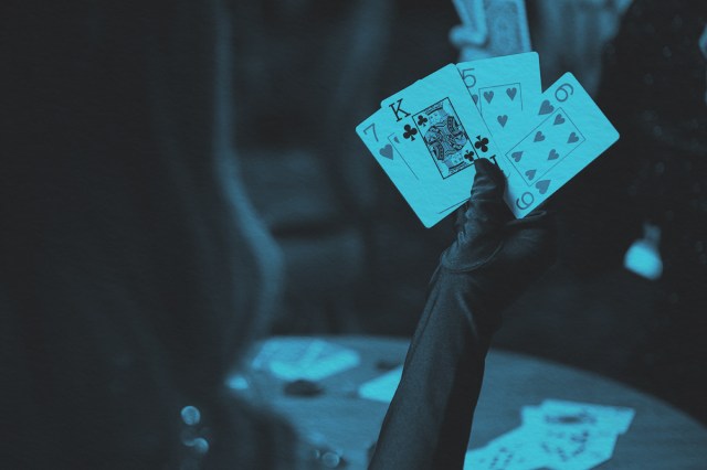 Gloved hand holding playing cards