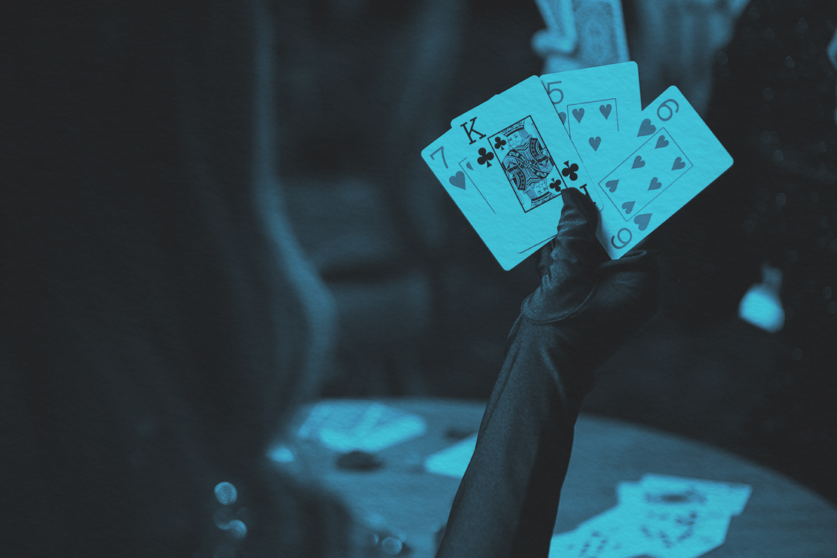 Gloved hand holding playing cards