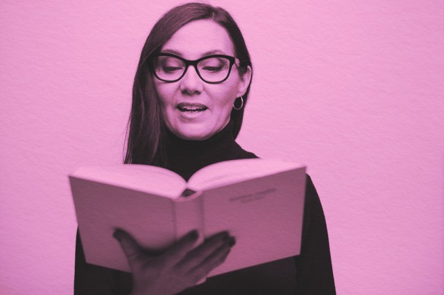 woman holding a book and reading out loud