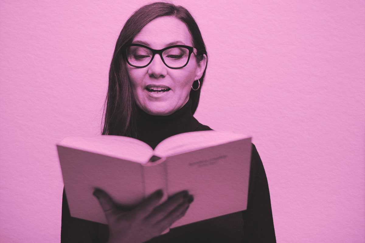 woman holding a book and reading out loud