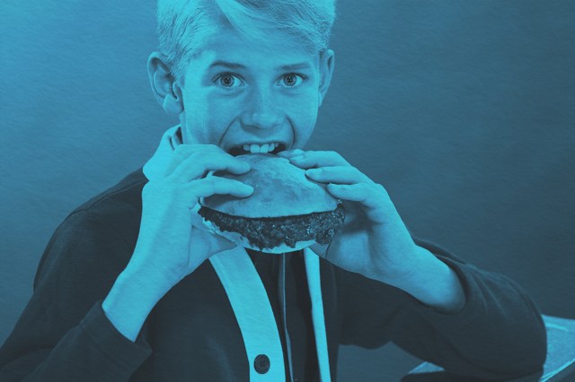 Young boy eating a hamburger